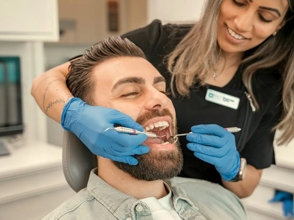 Dental hygienist laughing with a patient in the chair