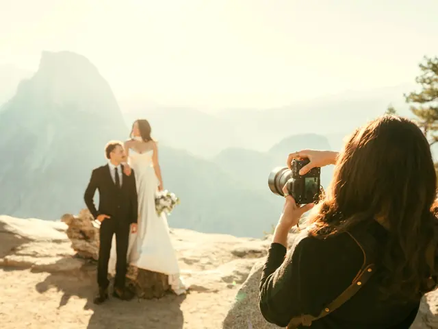 Photographer shooting a bride and groom on a mountain overlook